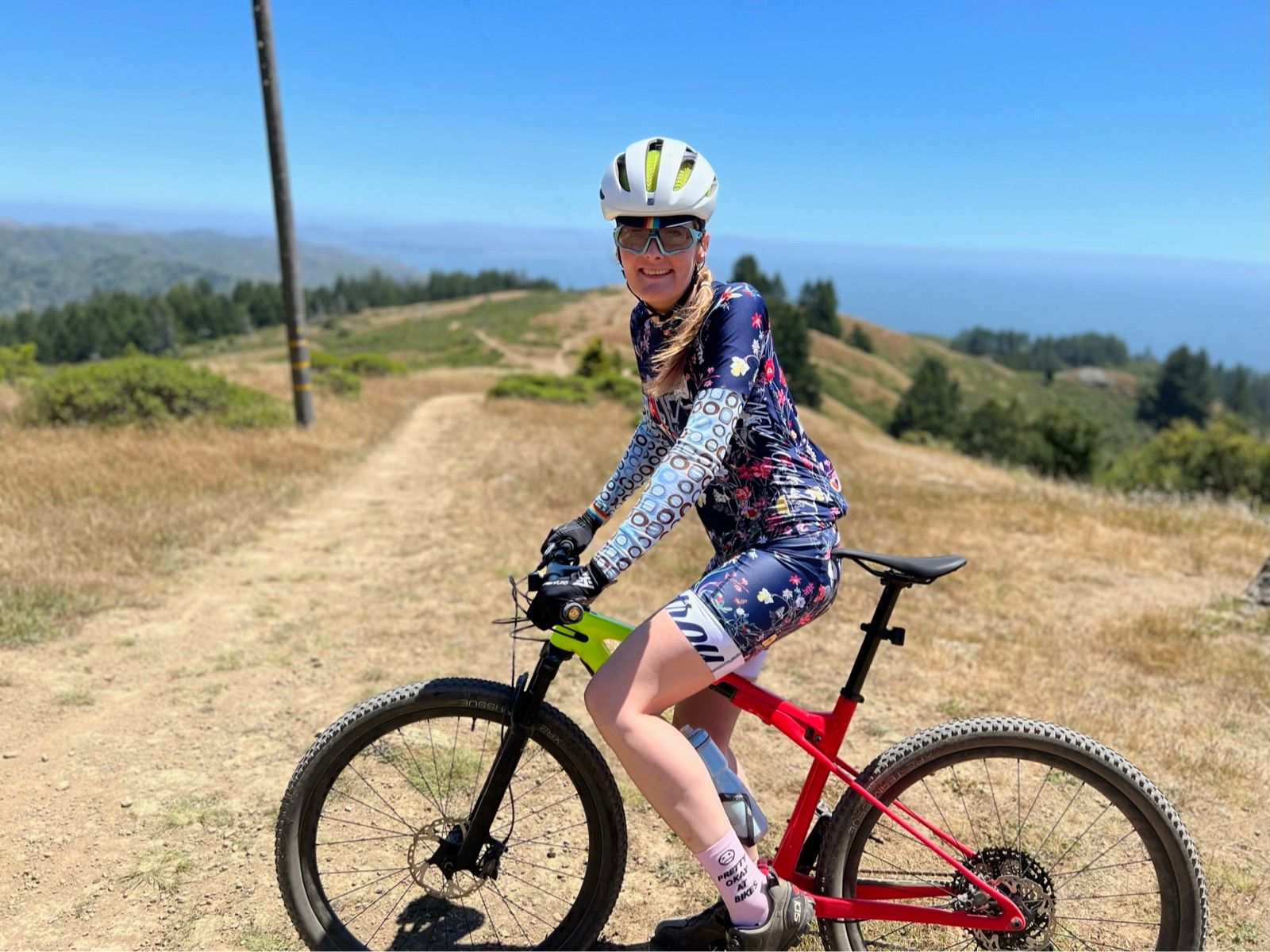 tracey on mountain bike with bay views