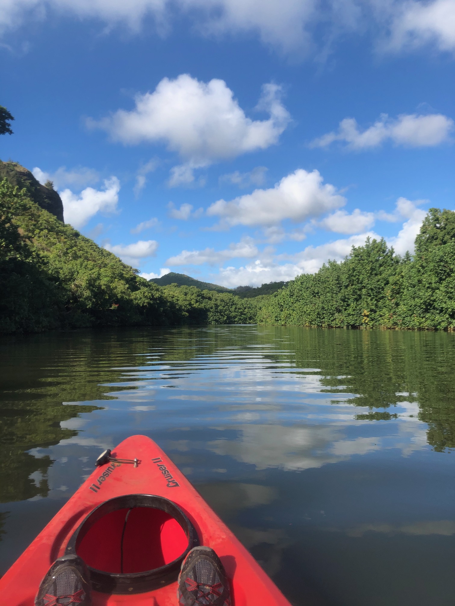 kayak in river with clouds