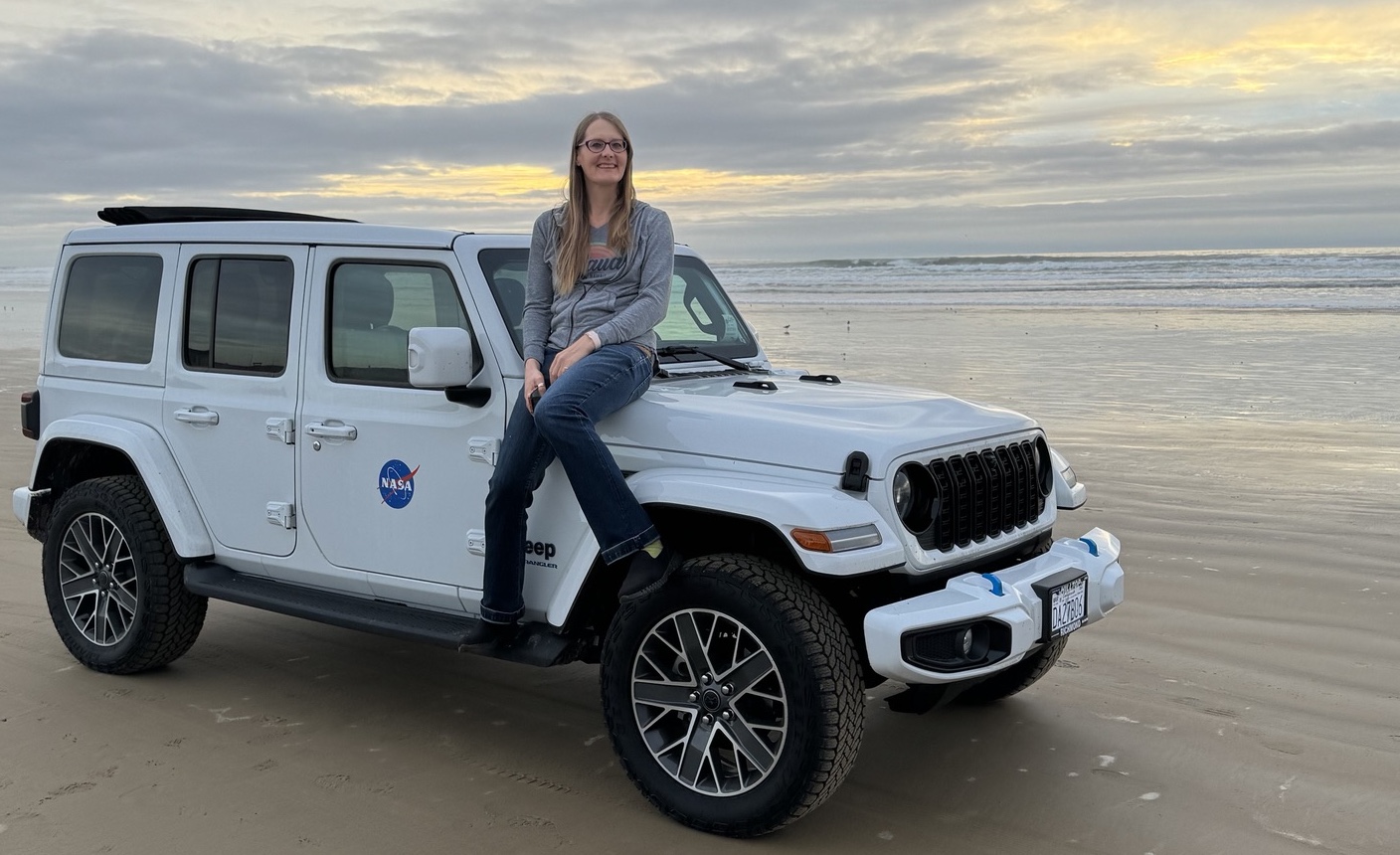 tracey sitting on new jeep at the beach